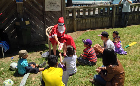 Regional Director Clare Menzies plays Santa with presents for the kids
