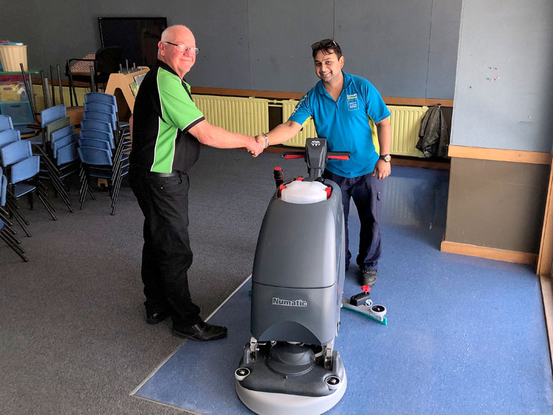 Sandeep Kumar receives his new floor scrubber from Dave McLeod.
