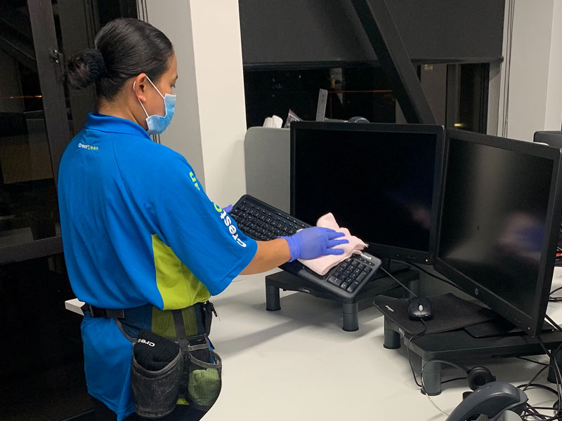 Lilibeth Agustin cleaning and sanitising office equipment.