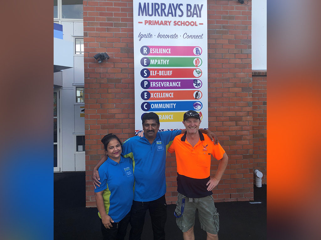 Cleaners and property manager standing outside school.