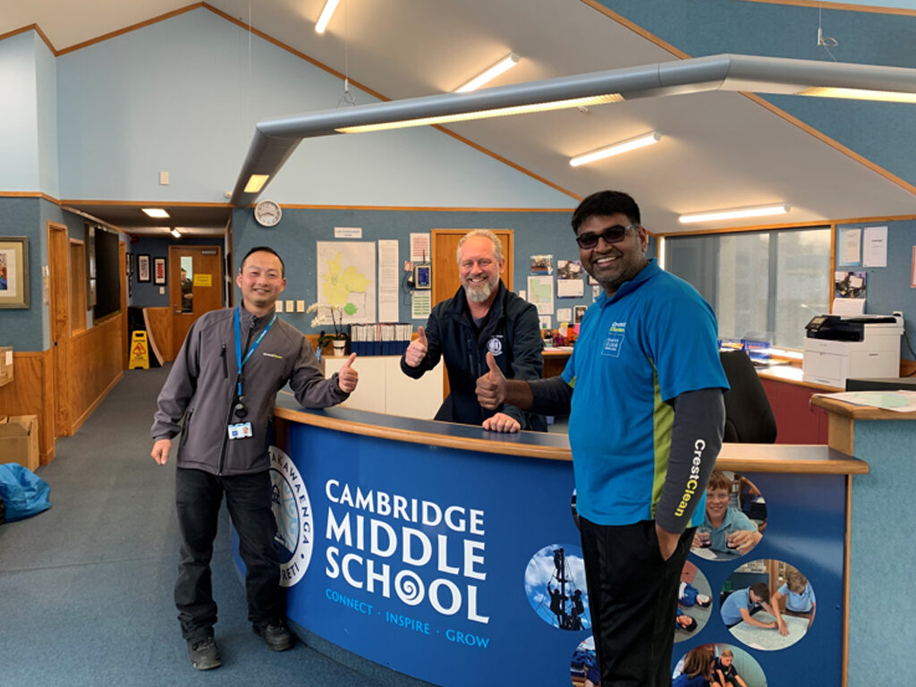 School property manager and cleaners giving thumbs-up.