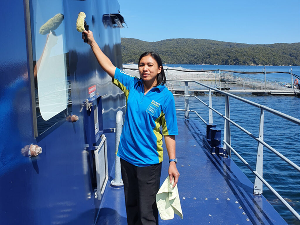 Woman cleaning a window on a barge.